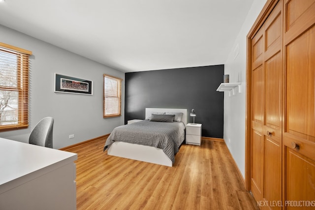 bedroom featuring multiple windows and light hardwood / wood-style floors