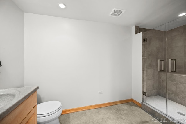 bathroom featuring vanity, tile patterned flooring, a shower with door, and toilet