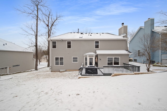 snow covered rear of property featuring a deck