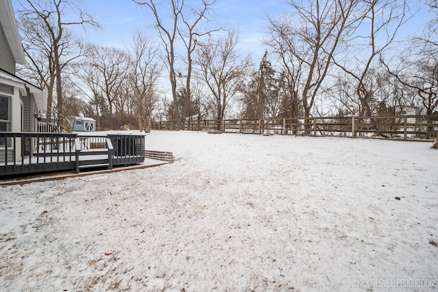 yard layered in snow with a wooden deck