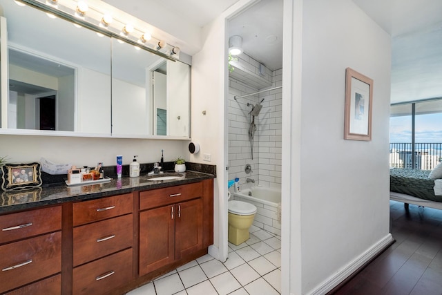 full bathroom featuring tiled shower / bath combo, wood-type flooring, toilet, and vanity