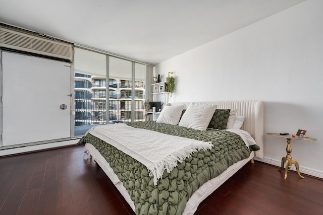 bedroom with access to outside, expansive windows, a baseboard radiator, and dark hardwood / wood-style floors