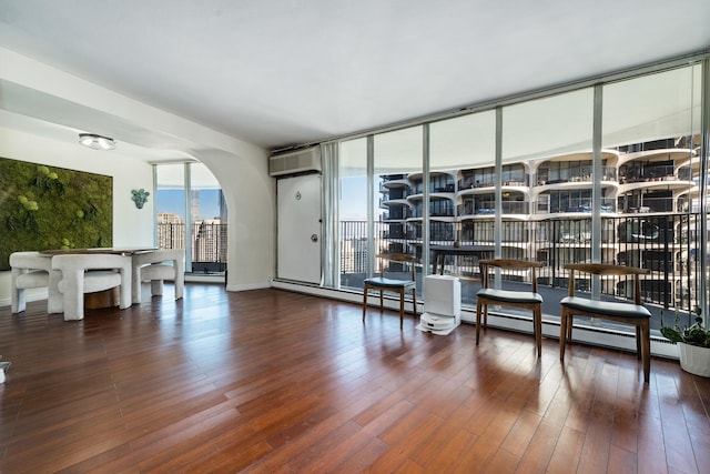 sitting room featuring dark hardwood / wood-style floors and a wall unit AC