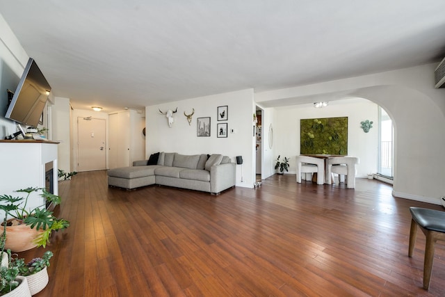 living room featuring a baseboard heating unit and dark wood-type flooring