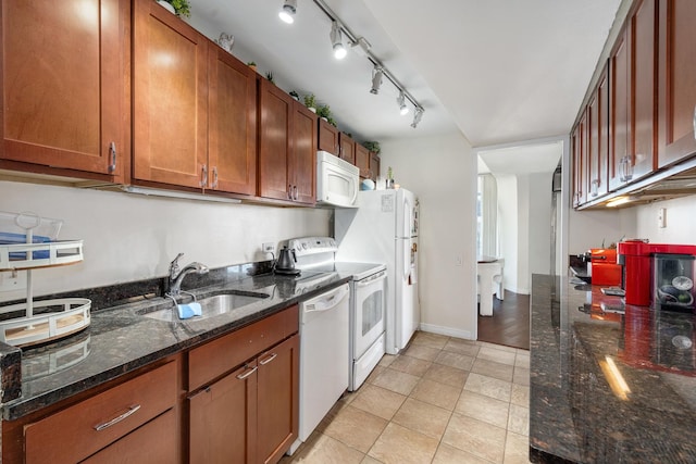 kitchen with sink, light tile patterned flooring, white appliances, and dark stone countertops