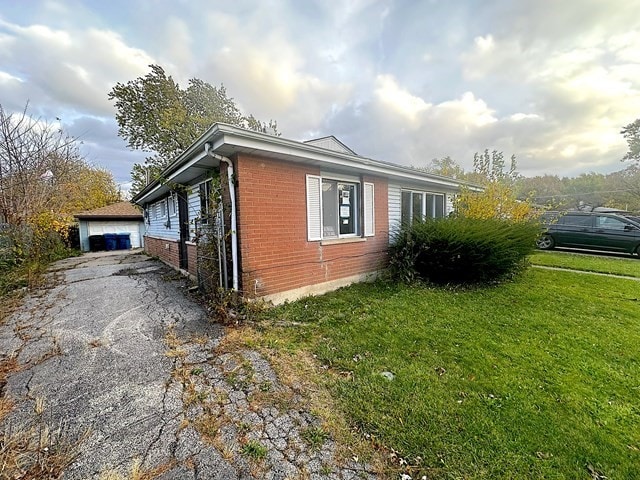 view of property exterior with a garage, an outdoor structure, and a yard