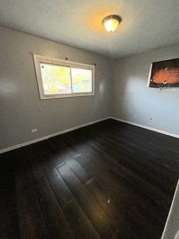 unfurnished room featuring dark hardwood / wood-style flooring