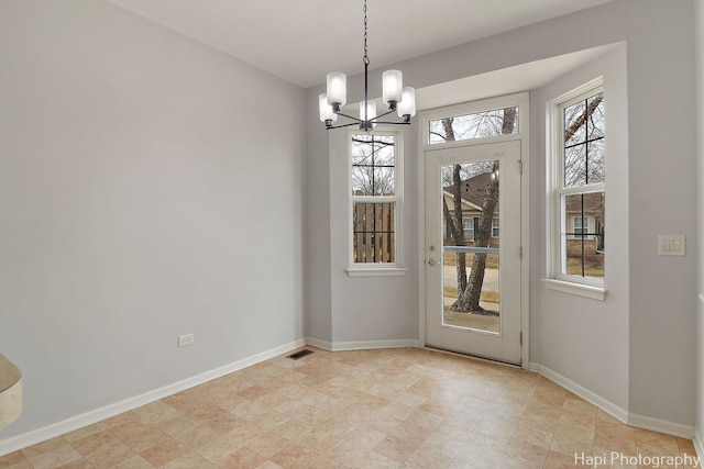 unfurnished dining area featuring baseboards, visible vents, and a healthy amount of sunlight