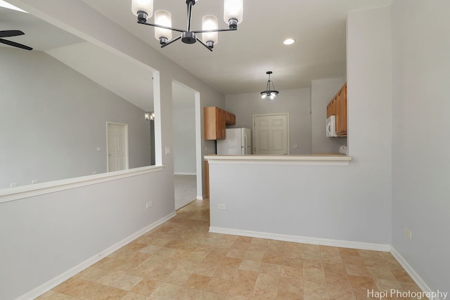 kitchen featuring ceiling fan with notable chandelier, white appliances, baseboards, light countertops, and pendant lighting