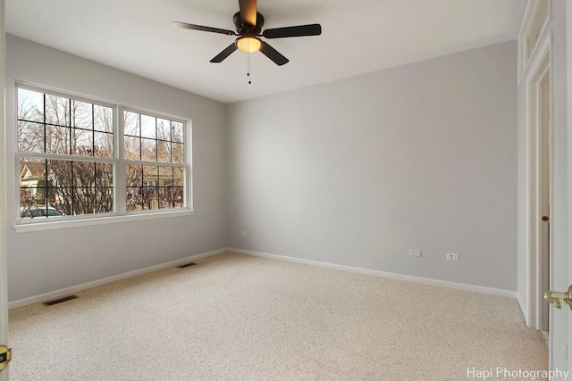 unfurnished room with carpet floors, ceiling fan, visible vents, and baseboards