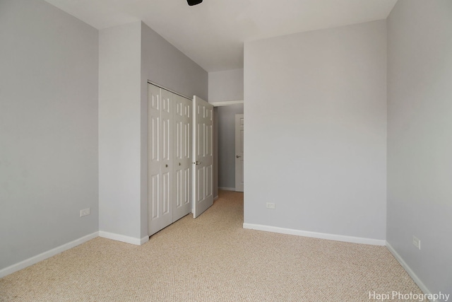 unfurnished bedroom with a closet, baseboards, and carpet flooring