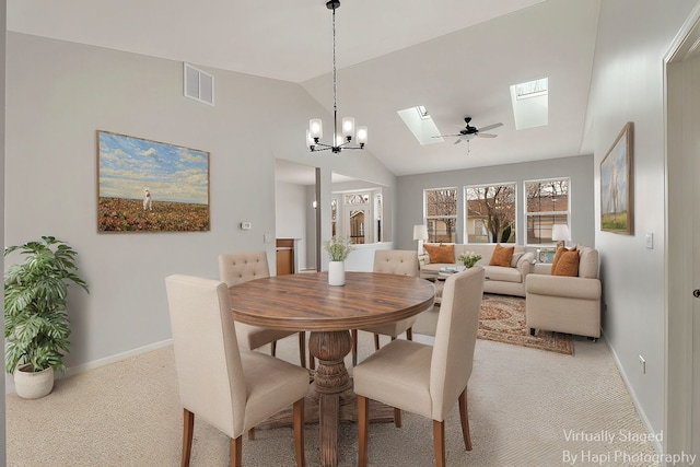 dining area featuring light carpet, vaulted ceiling with skylight, visible vents, and baseboards