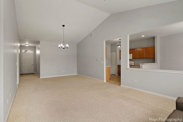 spare room featuring lofted ceiling, light carpet, visible vents, and baseboards