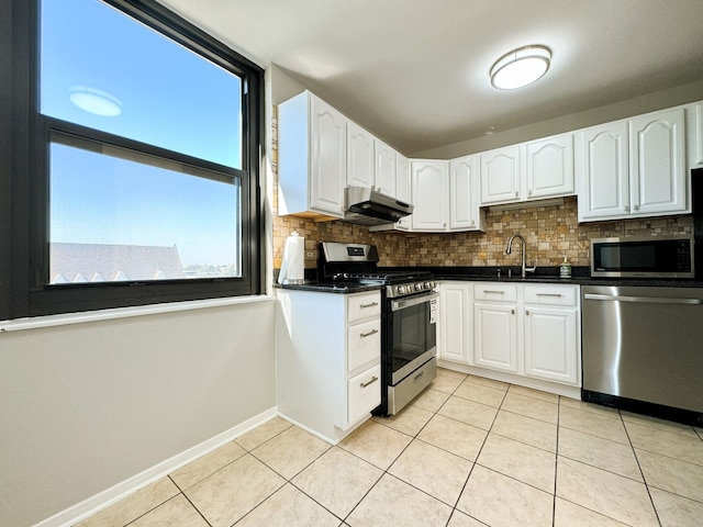 kitchen featuring sink, white cabinetry, light tile patterned floors, appliances with stainless steel finishes, and decorative backsplash