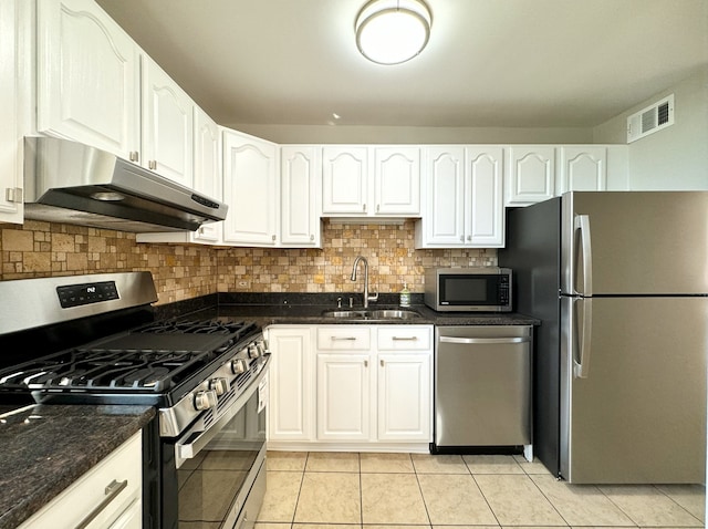 kitchen featuring sink, light tile patterned floors, stainless steel appliances, decorative backsplash, and white cabinets