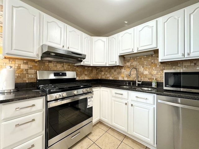 kitchen featuring stainless steel appliances, light tile patterned flooring, backsplash, and white cabinetry