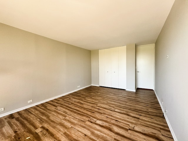 unfurnished bedroom featuring wood-type flooring and a closet