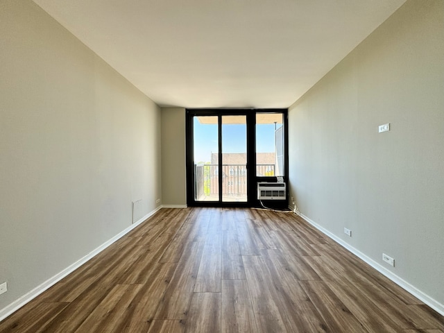 unfurnished room featuring dark hardwood / wood-style flooring and a wall of windows