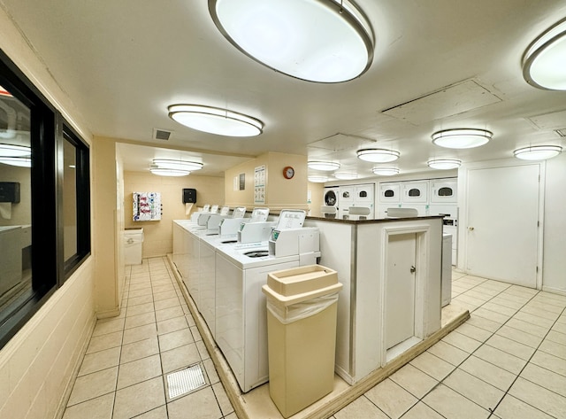 washroom with light tile patterned flooring and washing machine and clothes dryer