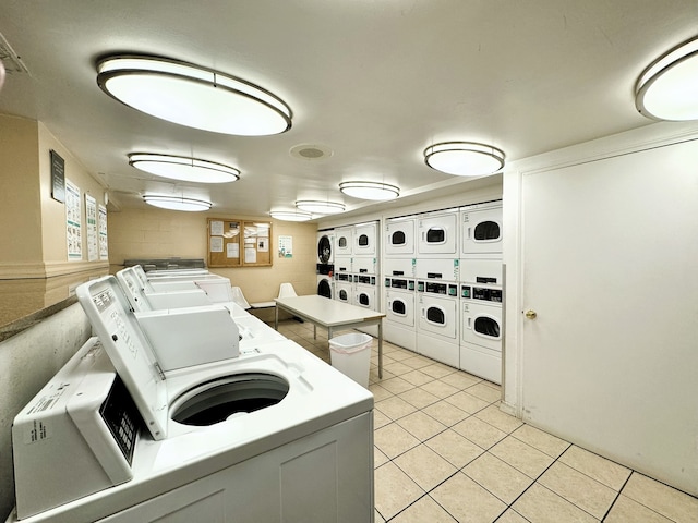 washroom featuring stacked washer / drying machine, light tile patterned floors, and washing machine and dryer