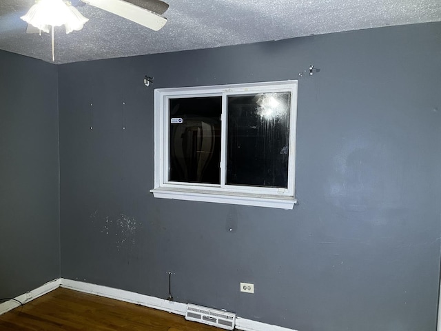 unfurnished room featuring ceiling fan, hardwood / wood-style floors, and a textured ceiling