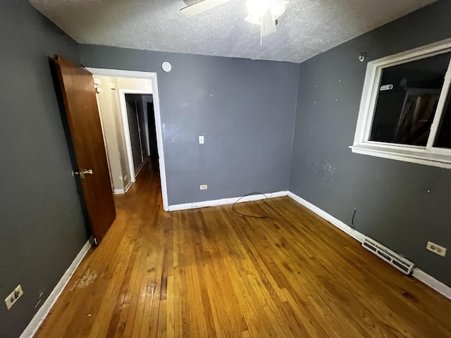 unfurnished room featuring wood-type flooring and a textured ceiling