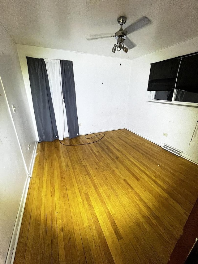 unfurnished room with ceiling fan, hardwood / wood-style floors, and a textured ceiling