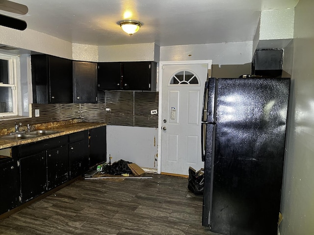 kitchen with sink, backsplash, black fridge, and dark hardwood / wood-style flooring