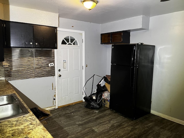 kitchen featuring black refrigerator, dark hardwood / wood-style flooring, and sink