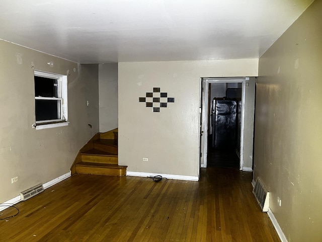 unfurnished room with dark wood-type flooring