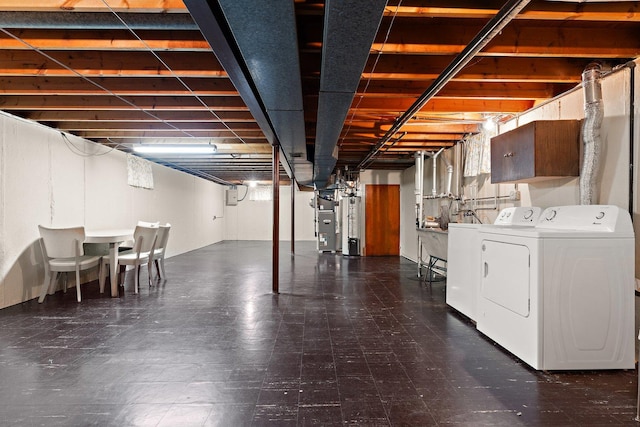 basement featuring heating unit and washer and clothes dryer