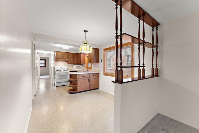 kitchen with tasteful backsplash, white appliances, and decorative light fixtures