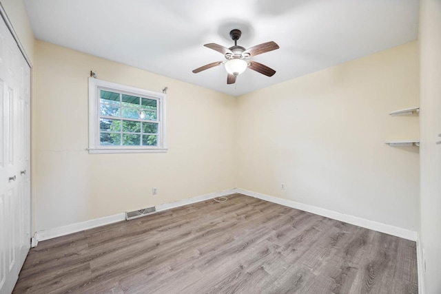 spare room with ceiling fan and wood-type flooring