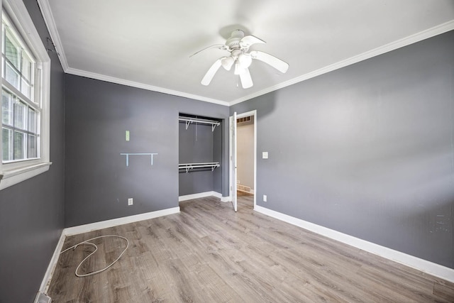 unfurnished bedroom featuring multiple windows, light hardwood / wood-style flooring, a closet, and ceiling fan