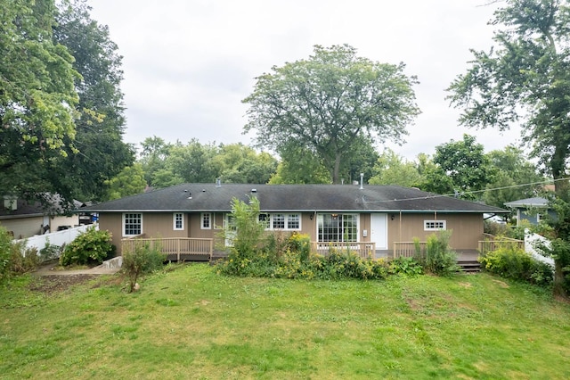 rear view of property with a lawn and a wooden deck