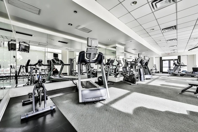 workout area with carpet flooring and a drop ceiling