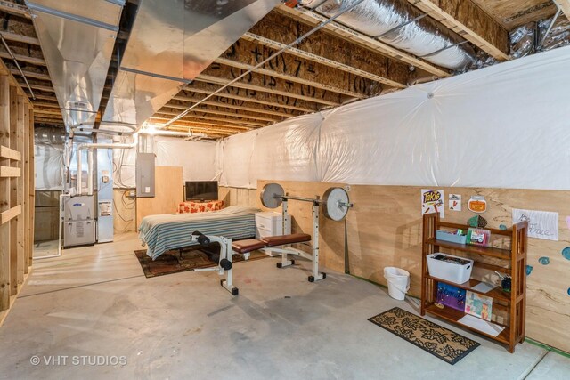 basement featuring heating unit and electric panel