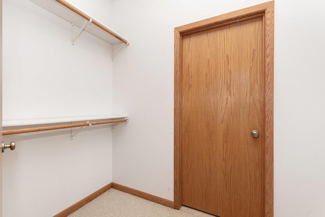 spacious closet featuring light carpet