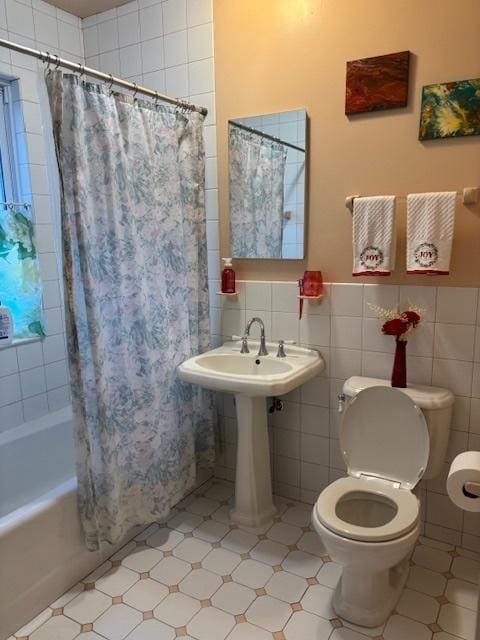 bathroom featuring tile walls, tile patterned flooring, shower / bath combination with curtain, and toilet