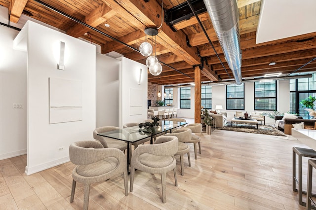 dining space featuring beam ceiling, wooden ceiling, and light hardwood / wood-style floors