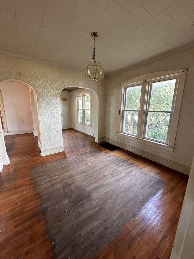 interior space featuring a notable chandelier, crown molding, and dark wood-type flooring