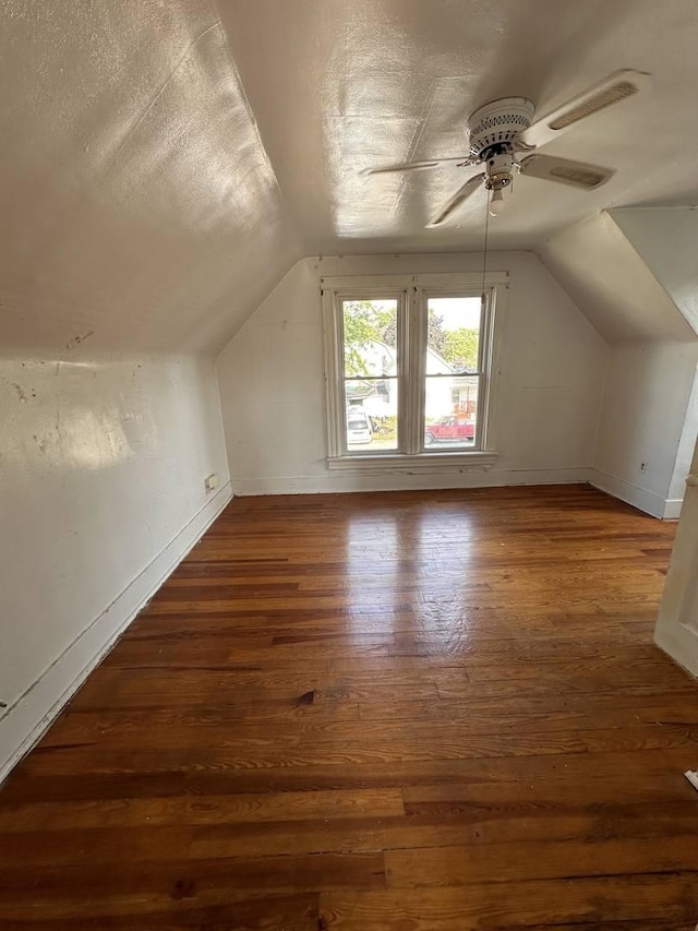bonus room featuring vaulted ceiling, ceiling fan, a textured ceiling, and dark hardwood / wood-style flooring