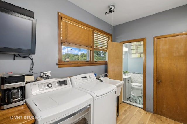 laundry room with light hardwood / wood-style floors and washing machine and clothes dryer