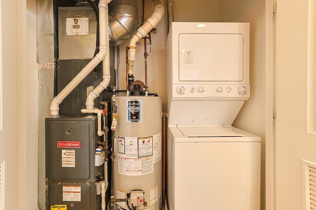 laundry area featuring water heater, stacked washer / drying machine, and heating unit