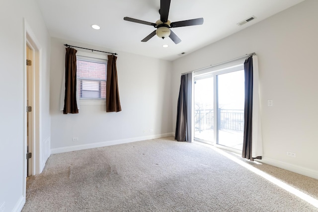 carpeted spare room featuring ceiling fan