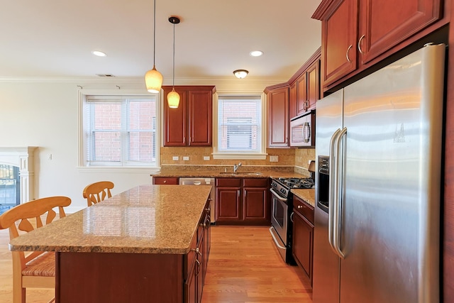 kitchen featuring a kitchen island, appliances with stainless steel finishes, pendant lighting, a kitchen breakfast bar, and decorative backsplash