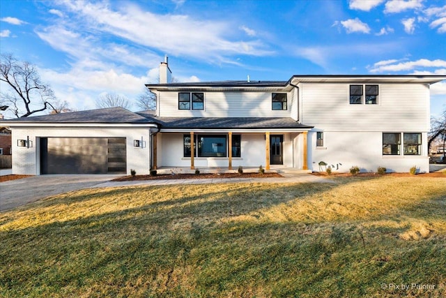 front of property featuring a garage, a front lawn, and covered porch