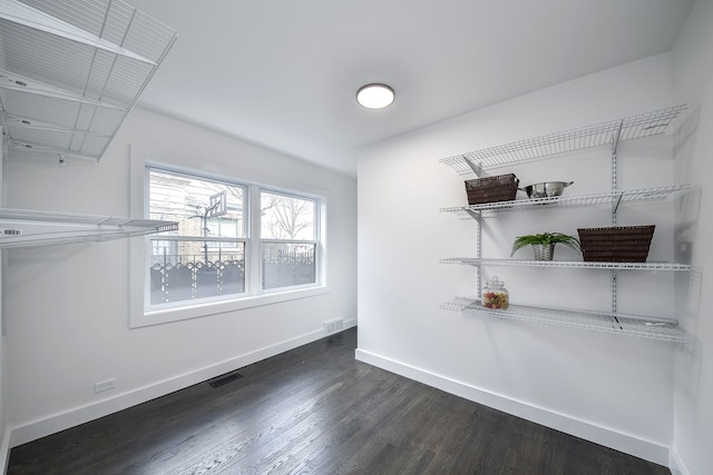 walk in closet with dark wood-type flooring and visible vents