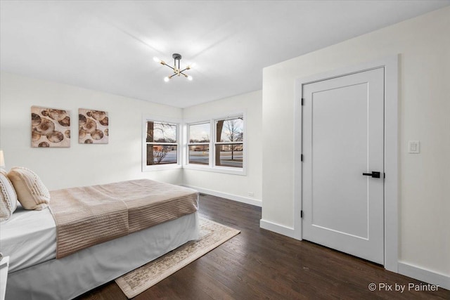 bedroom with dark hardwood / wood-style flooring and a chandelier