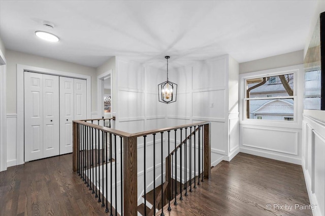 hallway with a notable chandelier and dark hardwood / wood-style floors